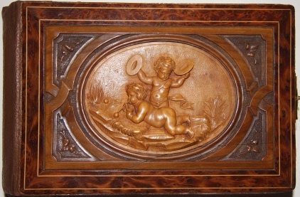 Image for Black Forest Photo Album with An Unusual Relief Depicting Putti, One Blowing Bubbles, the Other, Playing Cymbals